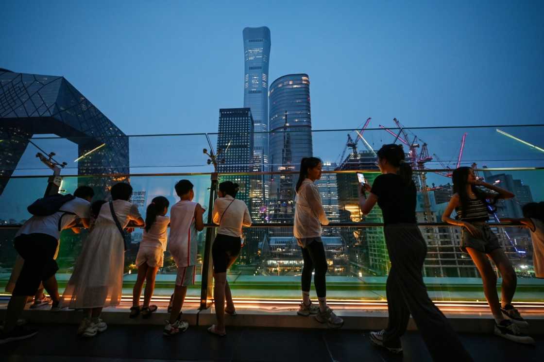 People look at buildings on the skyline from a viewing platform in a mall in Beijing’s central business district