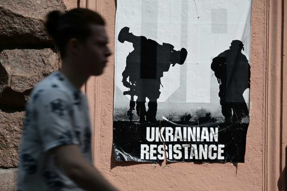A man passes by a poster reading "Ukrainian Resistance" in central Kyiv, on June 30, 2022 amid the Russian invasion of Ukraine A man passes by a poster reading "Ukrainian Resistance" in central Kyiv, on June 30, 2022 amid the Russian invasion of Ukraine