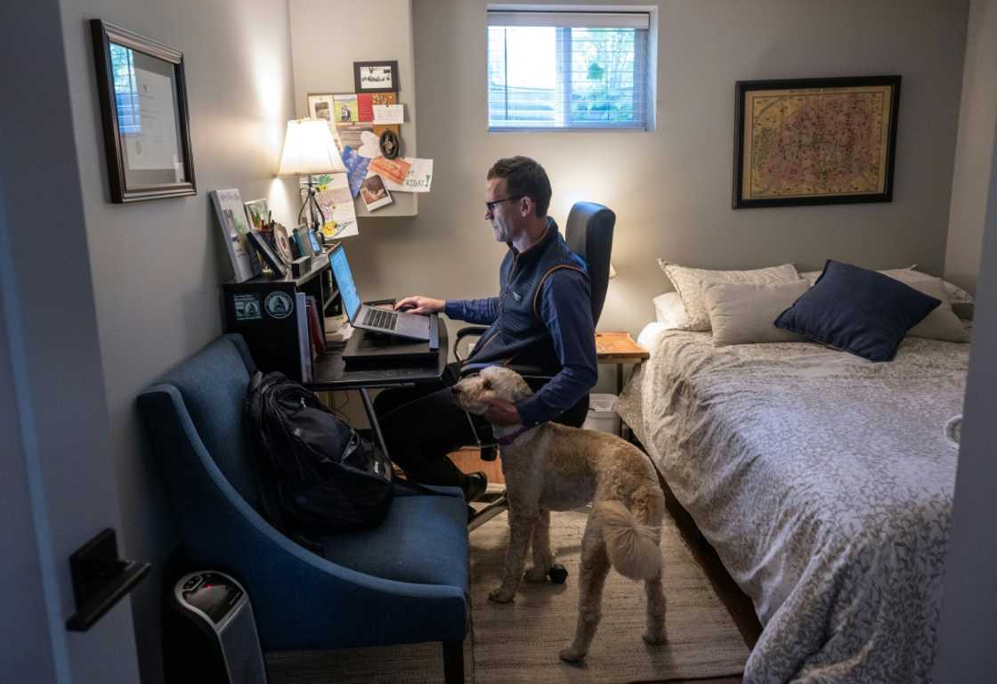Danny Crouch pets his dog as he sits in his basement working from home in Arlington, Virginia Danny Crouch pets his dog as he sits in his basement working from home in Arlington, Virginia
