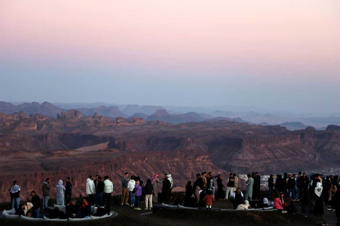 Tourists enjoy panoramic views of the ancient Saudi oasis city of Al-Ula, among a growing number who have beaten a path to the kingdom since it began issuing general tourism visas in 2019 Tourists enjoy panoramic views of the ancient Saudi oasis city of Al-Ula, among a growing number who have beaten a path to the kingdom since it began issuing general tourism visas in 2019