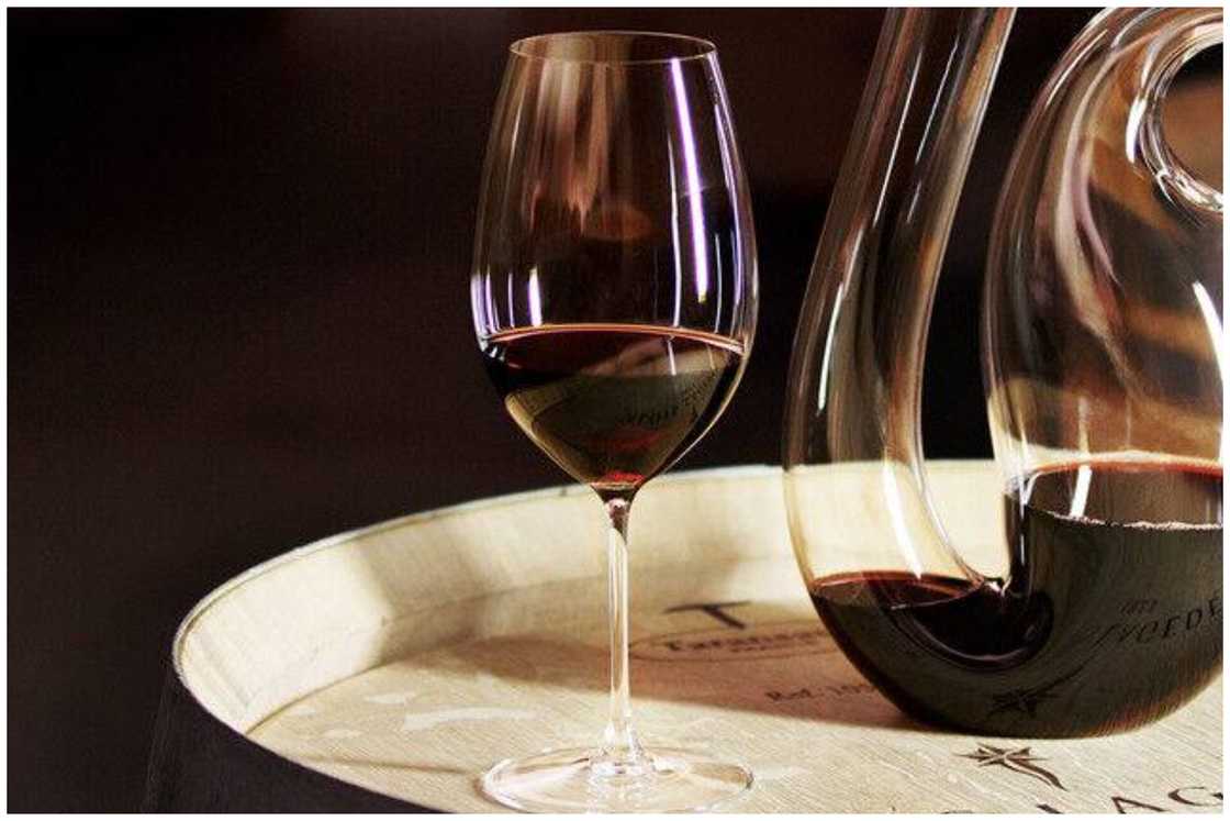 Shiraz glass put next to a glass jar of wine Shiraz glass put next to a glass jar of wine