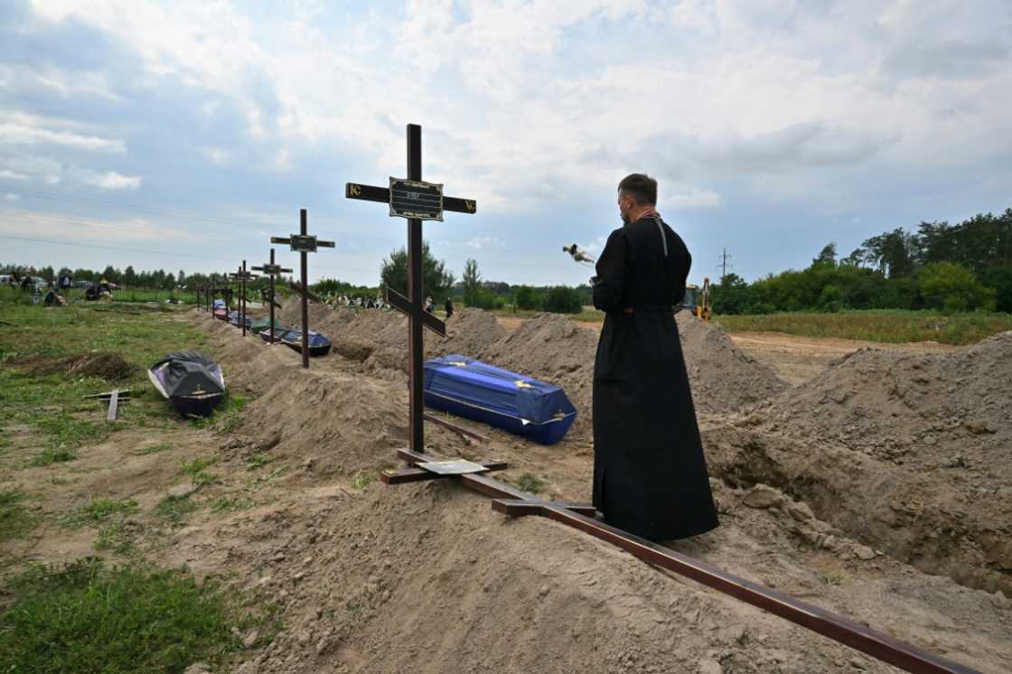 An Orthodox priest prays at a funeral in the town of Bucha near Kyiv, the site of alleged attrocities by Russia