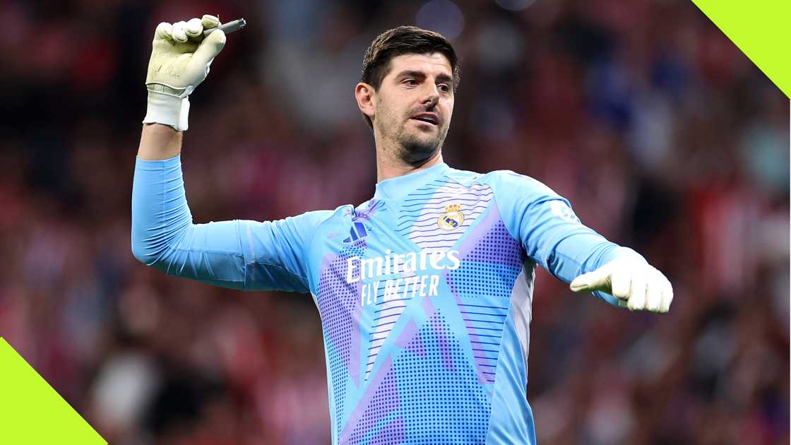 Real Madrid goalkeeper Thibaut Courtois throwing back an object hurled at him by Atletico Madrid fans behind his goalpost. Real Madrid goalkeeper Thibaut Courtois throwing back an object hurled at him by Atletico Madrid fans behind his goalpost.