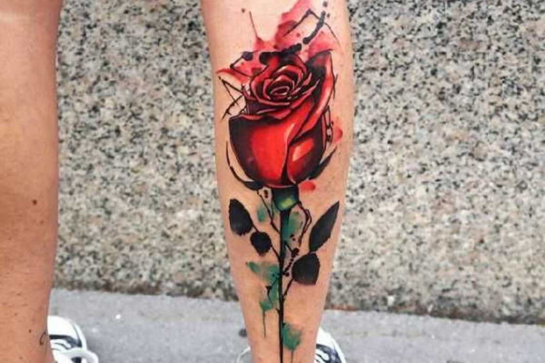 A vibrant watercolor rose leg tattoo A vibrant watercolor rose leg tattoo