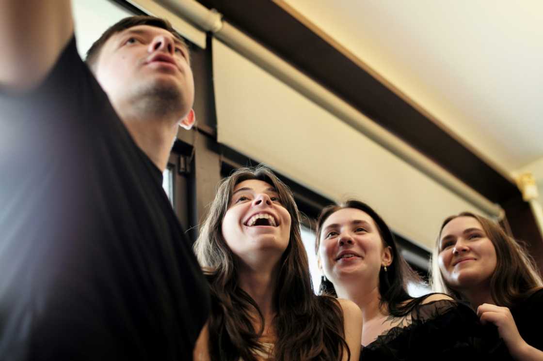 Ukrainian students (L-R) Roman Koval, Karyna Myshnova, Anna Fursyk and Alina Kuprii take a selfie during an interview with AFP at Tunghai University in Taichung, Taiwan