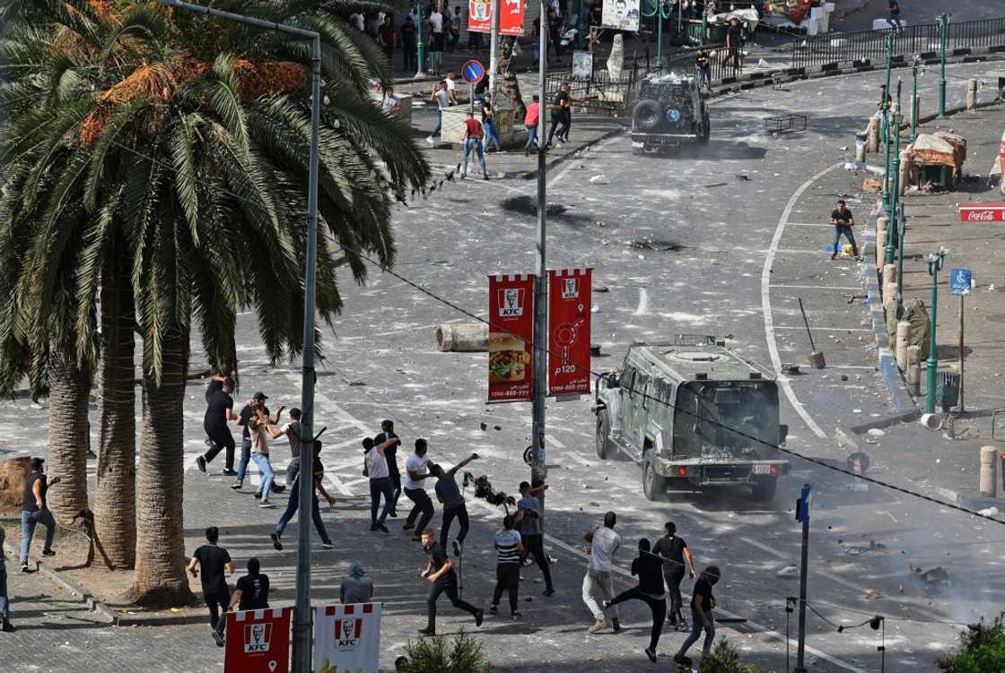 Young Palestinians engage in running battles with police in Nablus on Tuesday turning the heart of the West Bank city into a combat zone