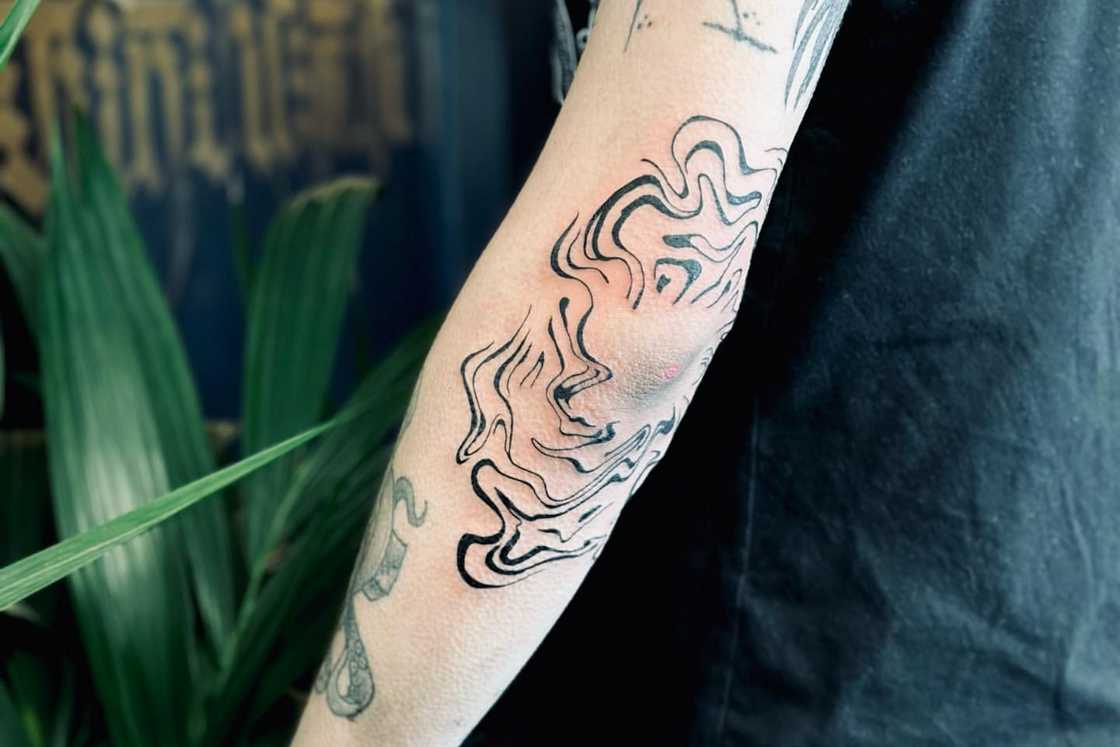 A black swirling elbow tattoo A black swirling elbow tattoo