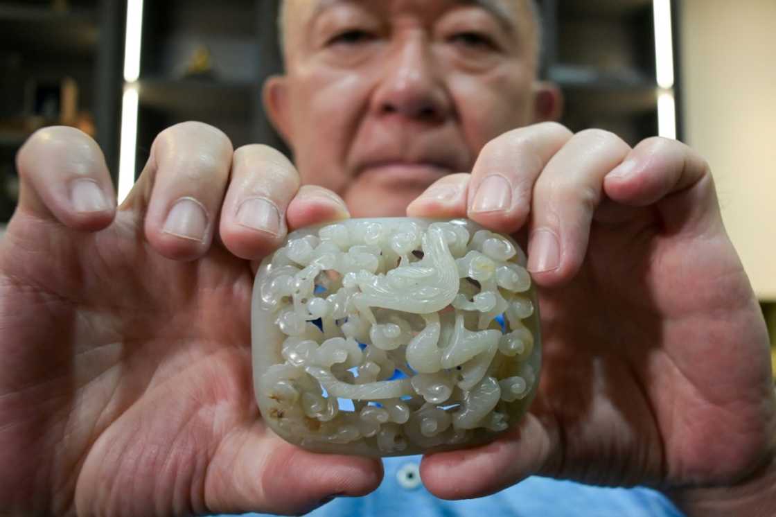 Chang Juben, chairman of Taiwan's Association of Jade Collectors, shows a Yuan dynasty jade belt ornament featuring a carving of a dragon among clouds Chang Juben, chairman of Taiwan's Association of Jade Collectors, shows a Yuan dynasty jade belt ornament featuring a carving of a dragon among clouds