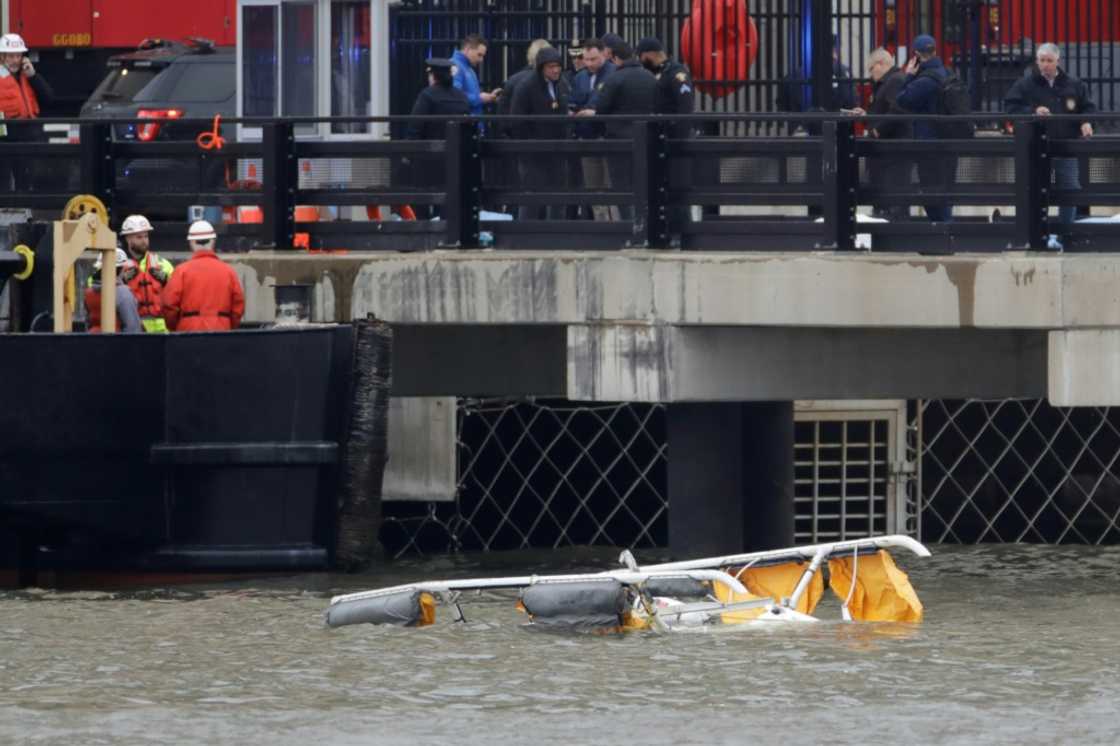 First responders are seen near the landing skids of a helicopter after it crashed into the Hudson River First responders are seen near the landing skids of a helicopter after it crashed into the Hudson River