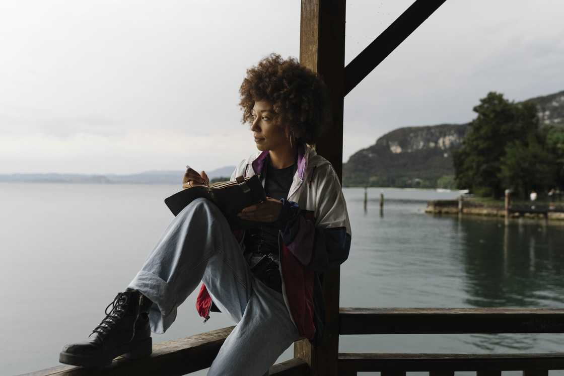 A woman journaling on a dock.