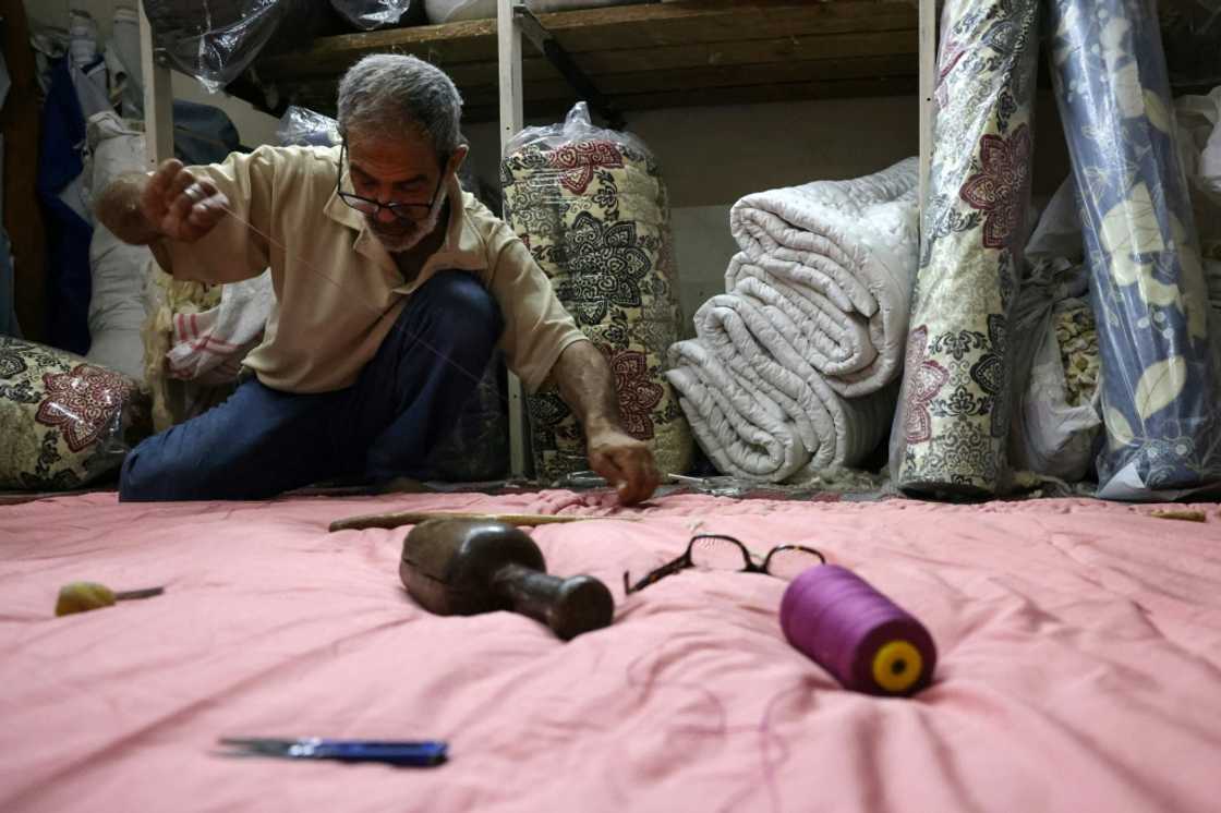 Mustafa al-Qadi, 67, often mends duvets under the soft light of a window during one of Lebanon's long power cuts Mustafa al-Qadi, 67, often mends duvets under the soft light of a window during one of Lebanon's long power cuts