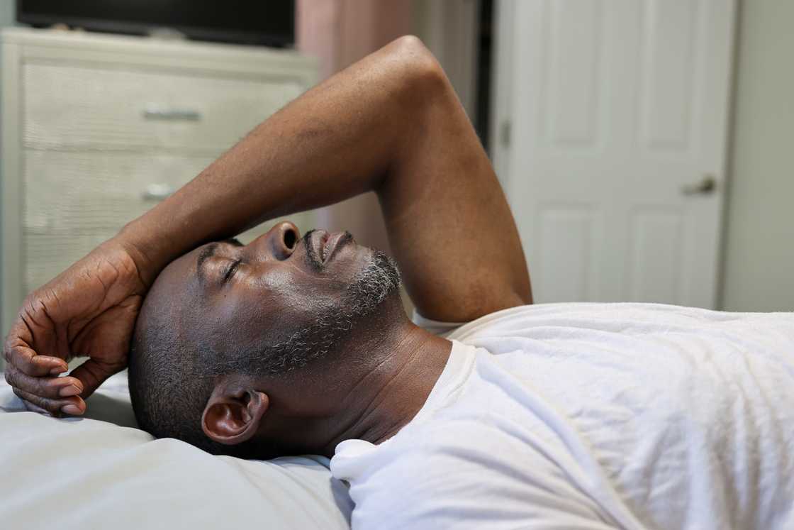 A man in pain while in bed A man in pain while in bed