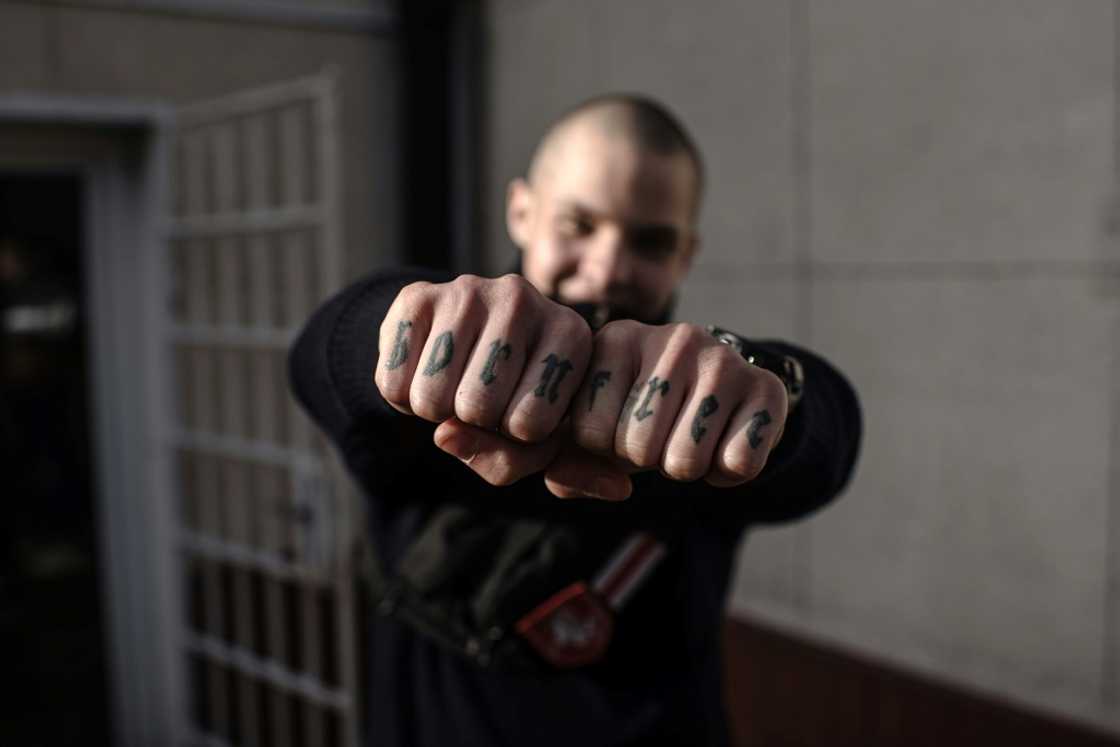Teenager Gleb Gunko shows his 'Born Free' knuckle tattoos before he joined the fight in Ukraine