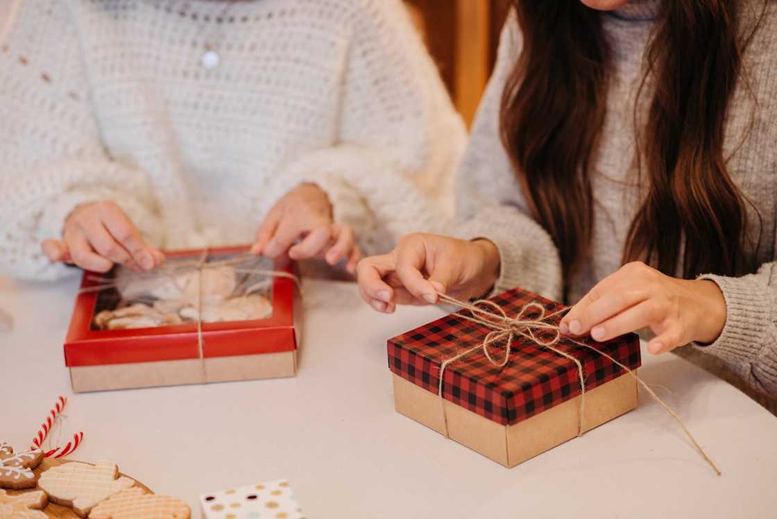 People tying boxes of cookies. People tying boxes of cookies.