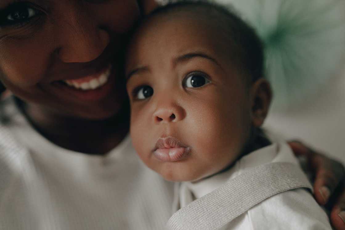 A close-up of a mother holding a baby. A close-up of a mother holding a baby.