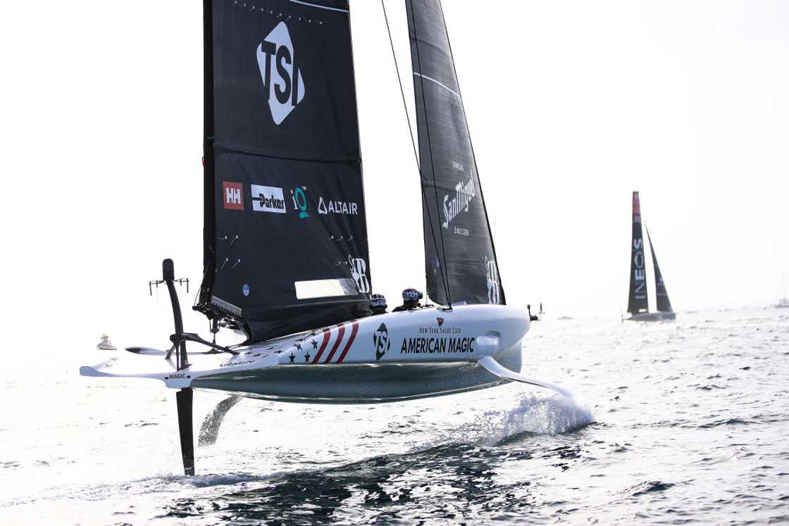 A modern racing yacht speeding through the water with colourful sails catching the wind.