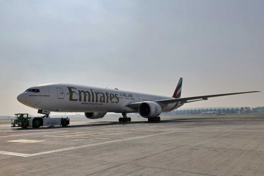 Ground crews prepare an Emirates Boeing 777-300ER aircraft, powering one of its engines with a hundred per cent Sustainable Aviation Fuel (SAF), for a demonstration flight at the Dubai International Airport in Dubai, on January 30, 2023. Emirates said it successfully flew a Boeing 777 powered by sustainable aviation fuel today, as the Middle East's largest airline aims to halve its jet fuel consumption. The Dubai-based carrier has used sustainable aviation fuel (SAF) since 2017, but said its test flight was "the first in the Middle East and North Africa to be powered by 100 percent SAF" in one of the plane's two engines.