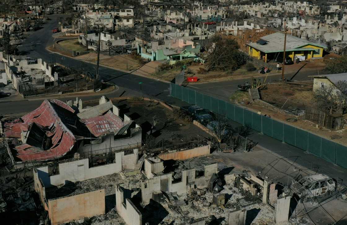 An aerial image shows destroyed homes and vehicles in the aftermath of the Maui wildfires in Lahaina, Hawaii on August 17, 2023