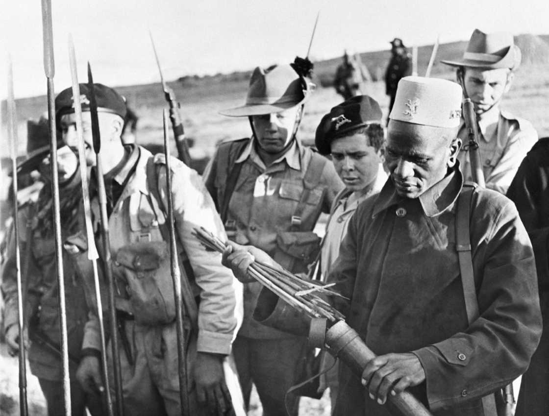 Soldiers examine spears and poisoned arrows used in the Mau Mau revolt -- one of the bloodiest episodes in British colonial rule Soldiers examine spears and poisoned arrows used in the Mau Mau revolt -- one of the bloodiest episodes in British colonial rule