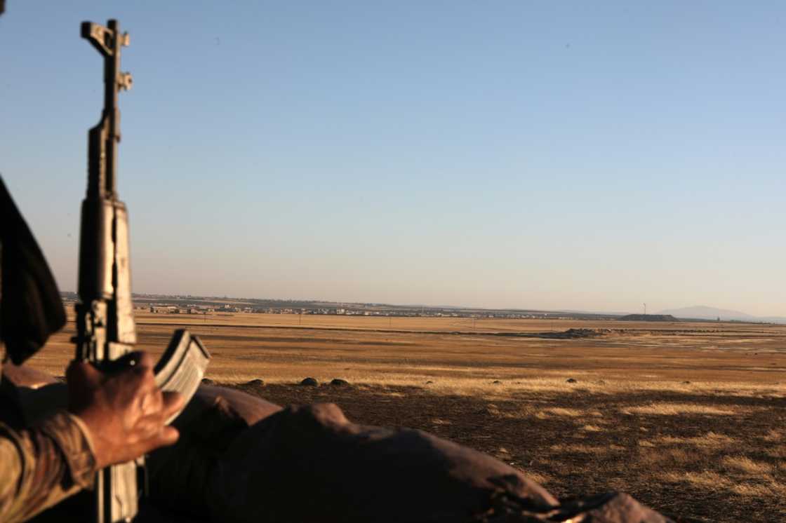 A Turkey-backed fighter in Syria looks towards the Kurdish-controlled area of Tal Rifaat A Turkey-backed fighter in Syria looks towards the Kurdish-controlled area of Tal Rifaat