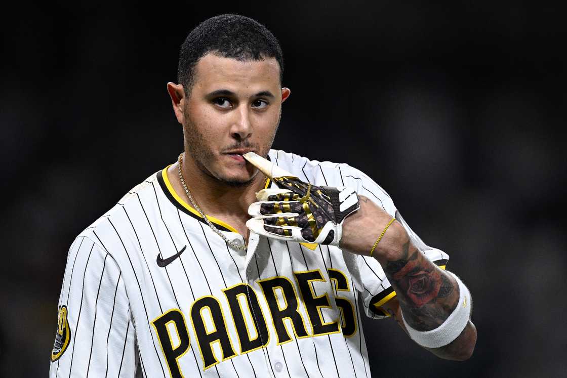 Manny Machado, #13 of the San Diego Padres, takes off his batting gloves