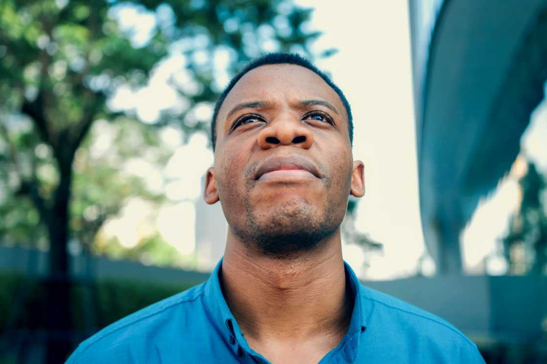A young African man is looking upward