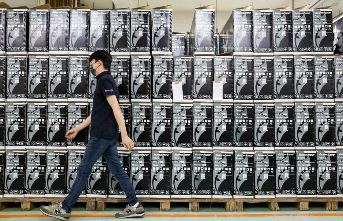 A worker walks past boxes of fold-up bicycles mostly destined for Europe and Asia at a factory of Pacific Cycles in Taoyuan on April 30, 2025 A worker walks past boxes of fold-up bicycles mostly destined for Europe and Asia at a factory of Pacific Cycles in Taoyuan on April 30, 2025