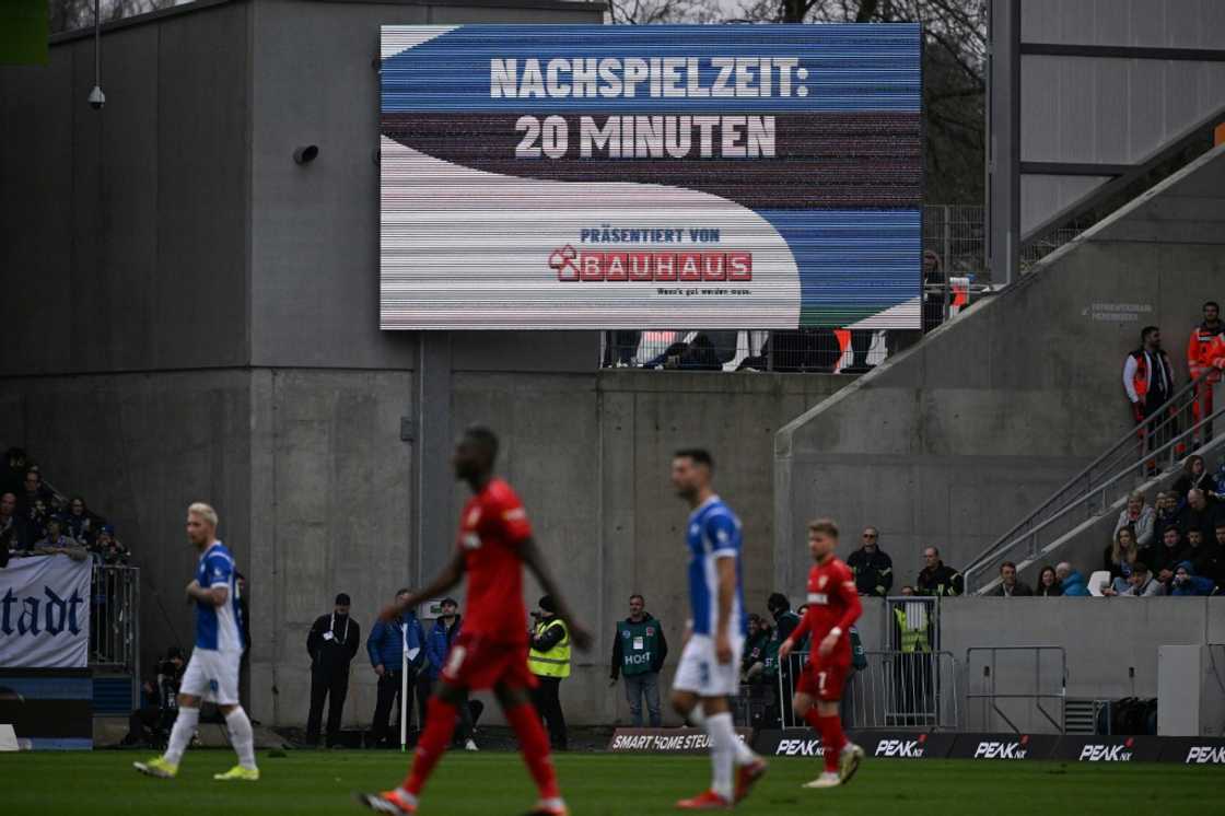 Anger: A display indicates 20 minutes of injury time due to fan protests during the Bundesliga match between Darmstadt and Stuttgart Anger: A display indicates 20 minutes of injury time due to fan protests during the Bundesliga match between Darmstadt and Stuttgart