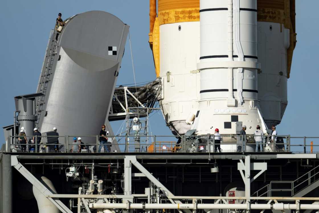 Engineers work on the Tail Service Mast Umbilical of the Artemis I unmanned lunar rocket as it sits on launch pad 39B at NASA's Kennedy Space Center Engineers work on the Tail Service Mast Umbilical of the Artemis I unmanned lunar rocket as it sits on launch pad 39B at NASA's Kennedy Space Center