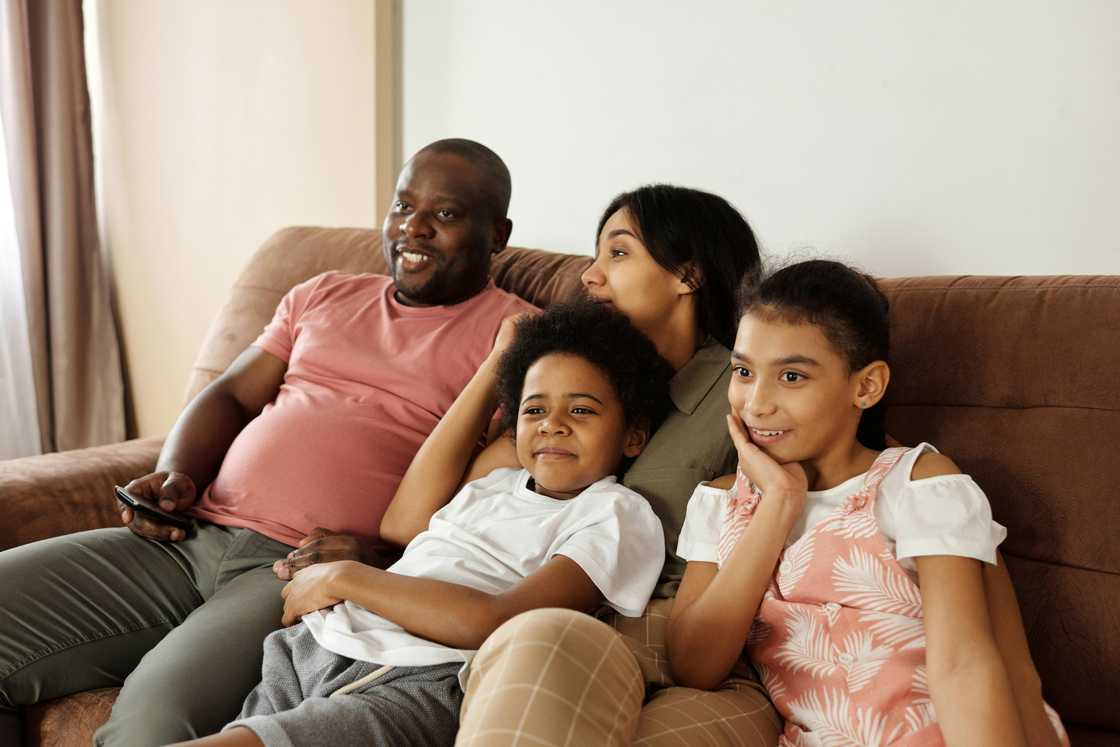 Happy family sitting on a couch and watching TV Happy family sitting on a couch and watching TV