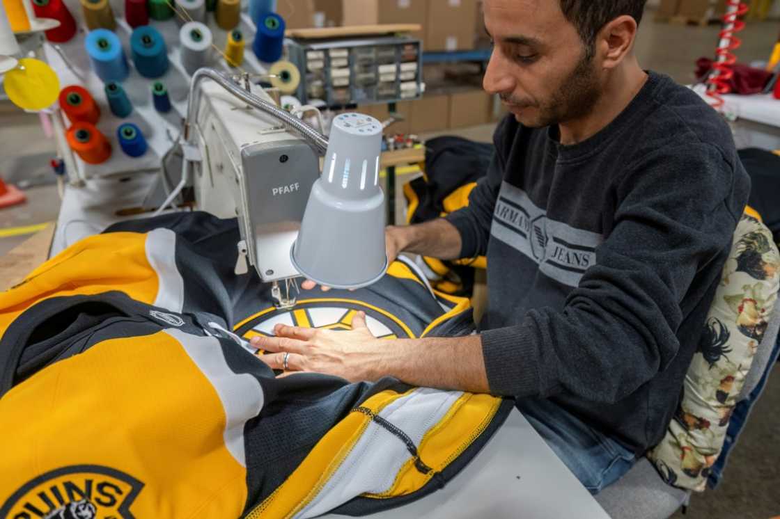 An employee works on Boston Bruins jerseys at SP Apparel in Saint-Hyacinthe, Quebec, Canada, on September 27, 2024. In the 260-employee SP Apparel factory, the jerseys of 32 NHL teams have been made for 50 years, and those for the Olympic ice hockey teams for 25 years.