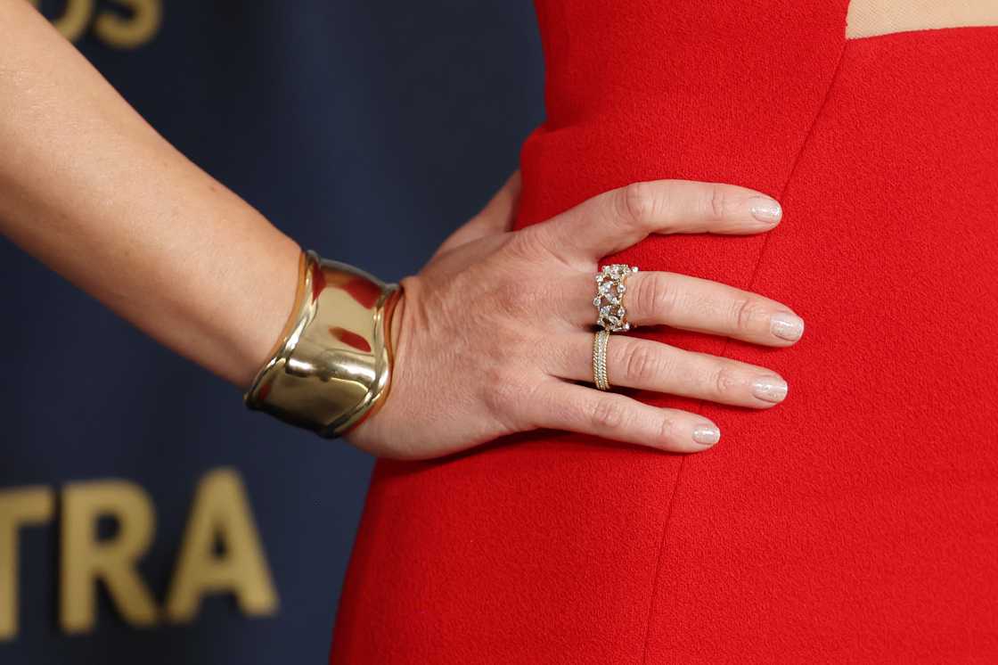 A woman in red wears a gold cuff around her wrist A woman in red wears a gold cuff around her wrist