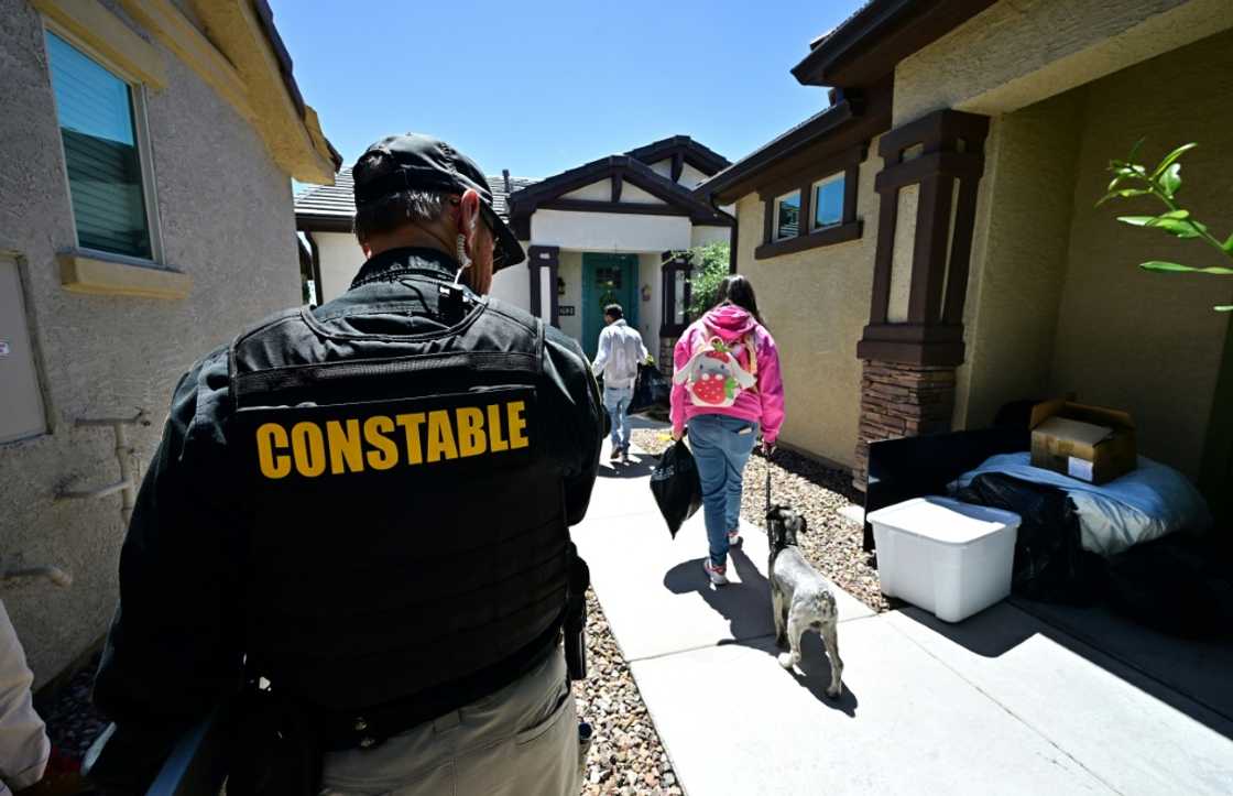 Lennie McCloskey, Constable of Manistee Justice Precint in Maricopa County watches as a family who has just been evicted carry out their belongings on April 15, 2024 in Phoenix, Arizona