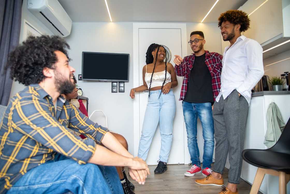 A group of friends laughing and chatting together in a modern living space. A group of friends laughing and chatting together in a modern living space.
