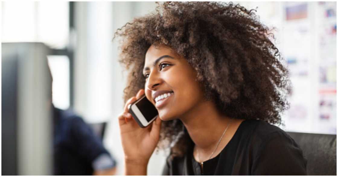 A woman smiles as she receives a follow-up call from a real estate agent