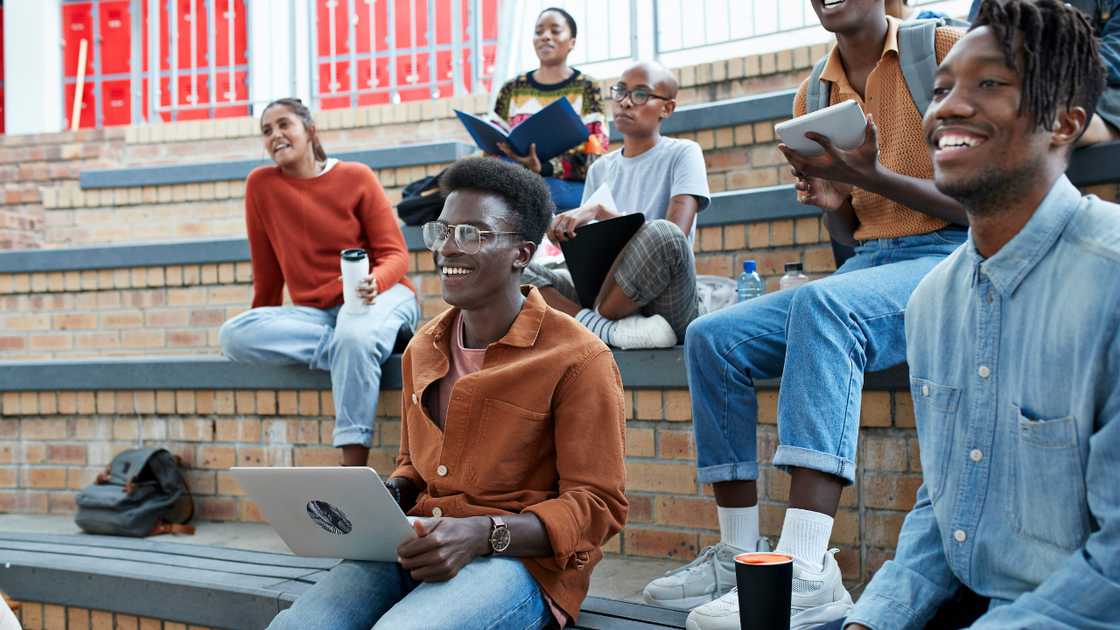 Students enjoying while sitting on amphitheater at university campus