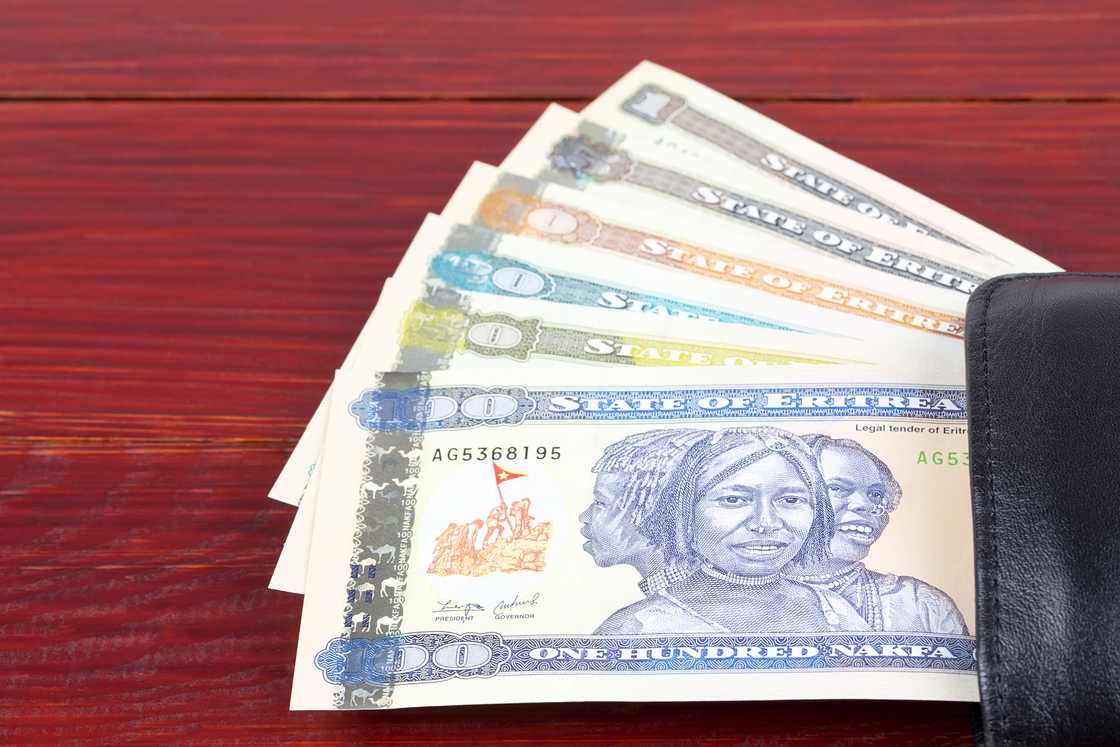 Eritrean Nakfa in the black wallet on a wooden background