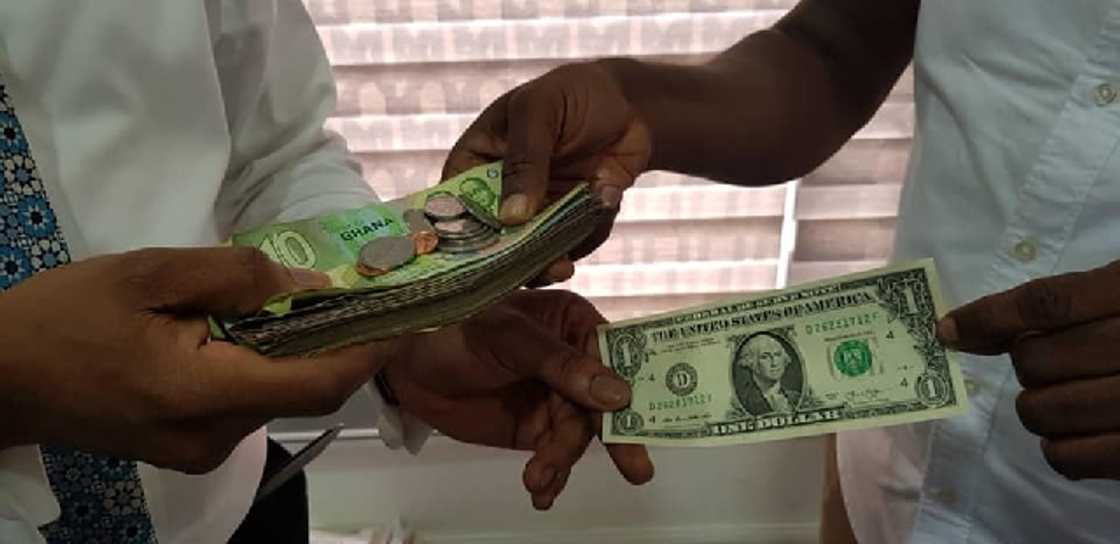 A stock image showing Ghana cedi notes and one US dollar. A stock image showing Ghana cedi notes and one US dollar.