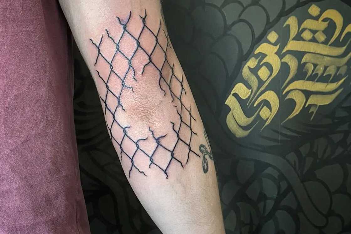 A unique back broken fence elbow tattoo A unique back broken fence elbow tattoo