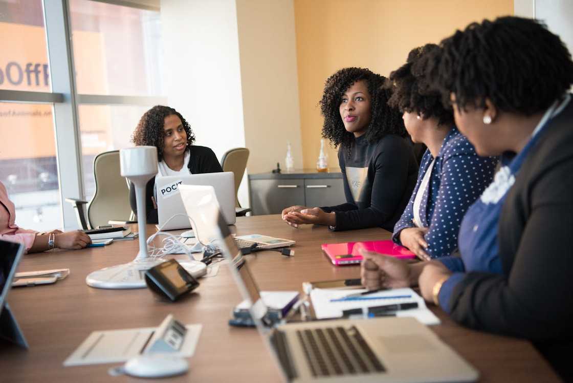 A group of women sit around a conference table during a work meeting.