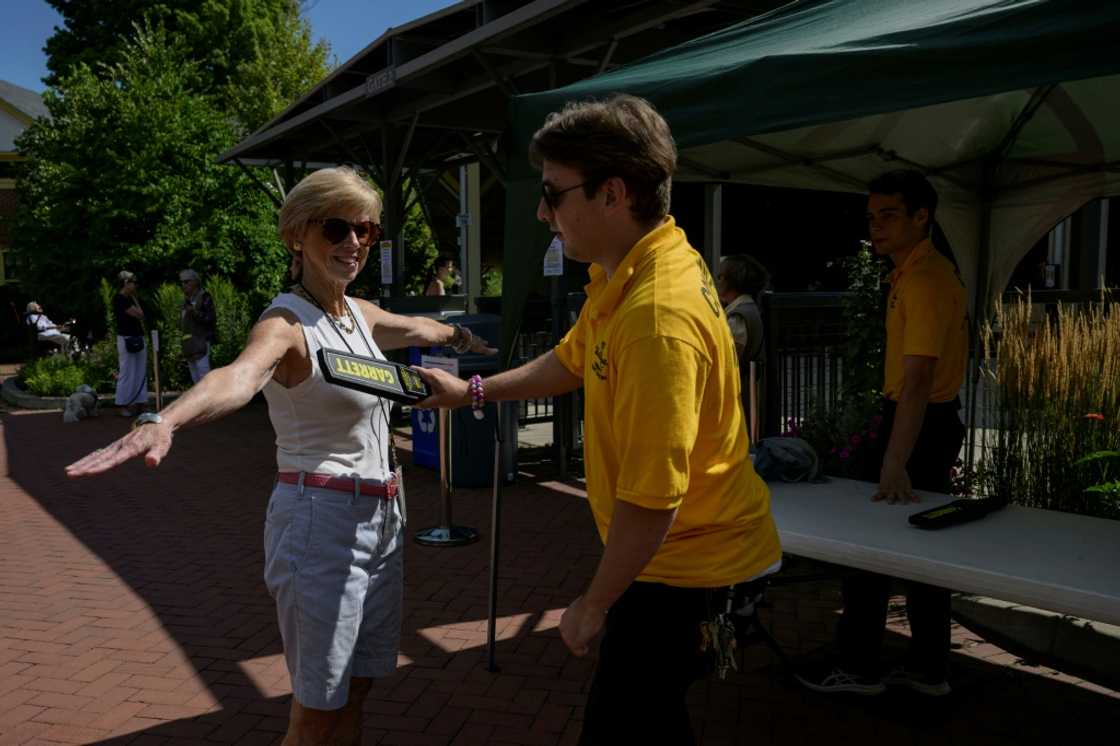 A woman is screened on August 20, 2022, by a security guard before entering the Chautauqua Institution amphitheater where author Salman Rushdie was attacked