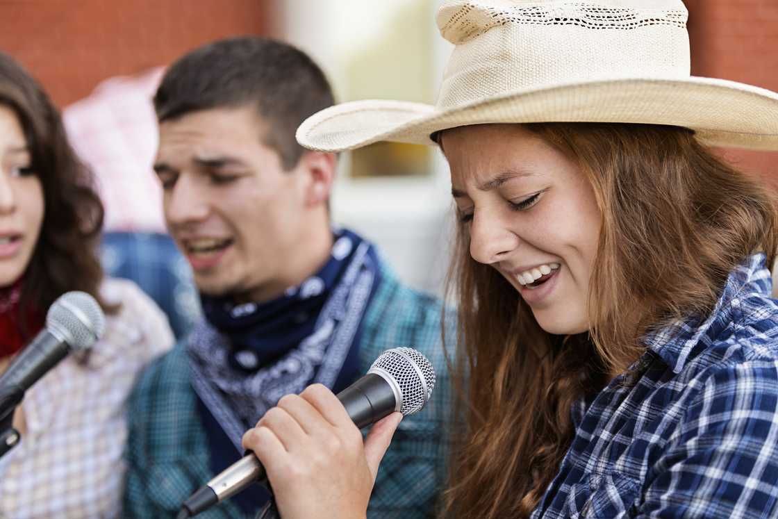 Young people singing country karaoke together Young people singing country karaoke together