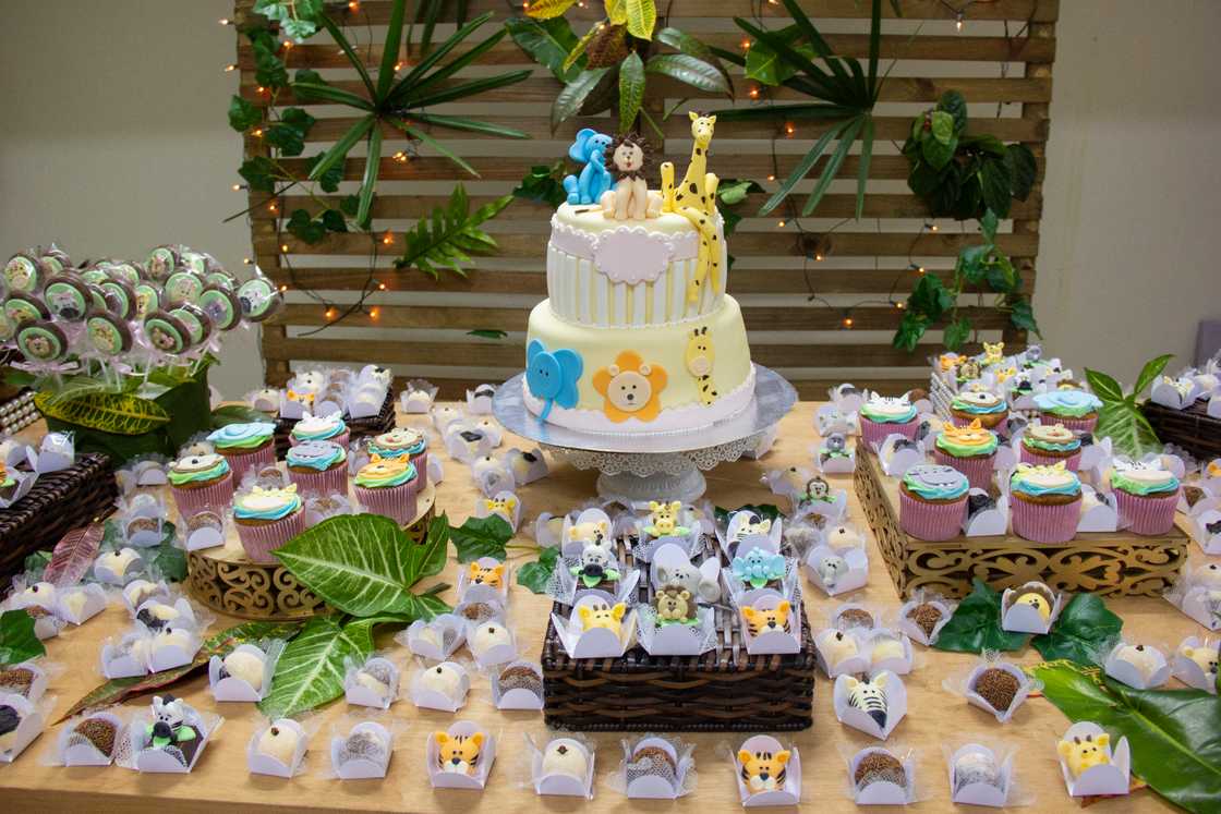 Children's table decoration with birthday cake, candies, cupcakes, chocolates and brigadeiro on the rustic wooden table