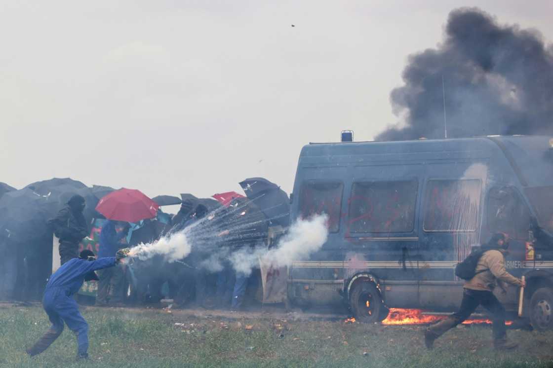 A protester attacks riot police during clashes over irrigation reservoirs in Sainte-Soline, France, on March 25 A protester attacks riot police during clashes over irrigation reservoirs in Sainte-Soline, France, on March 25