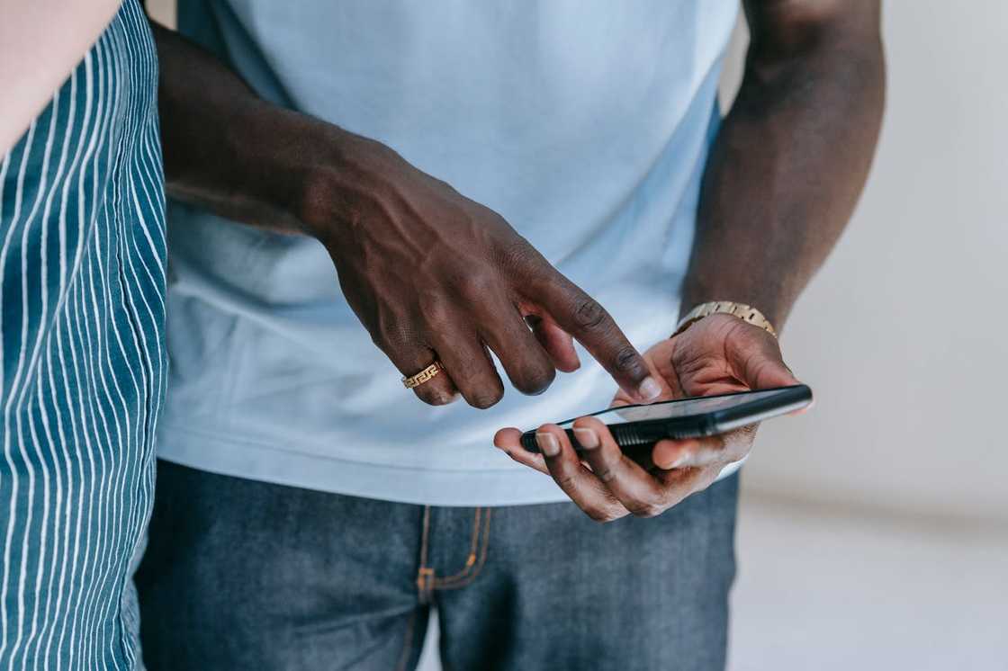 Hands holding a smartphone while pointing at the screen during a conversation. Hands holding a smartphone while pointing at the screen during a conversation.