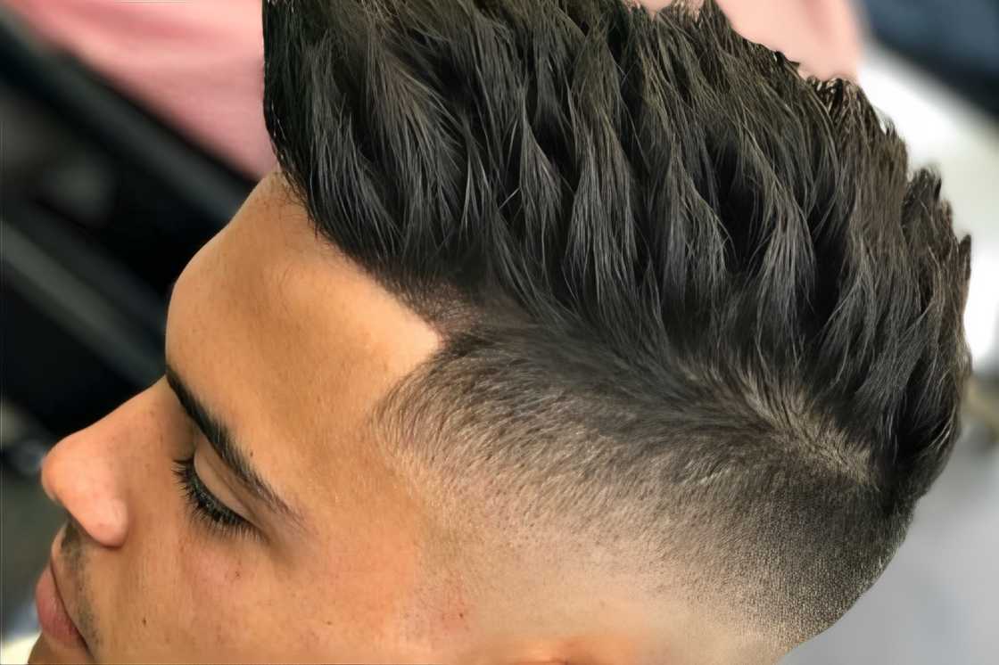 A young man is rocking a fade and spiky haircut A young man is rocking a fade and spiky haircut