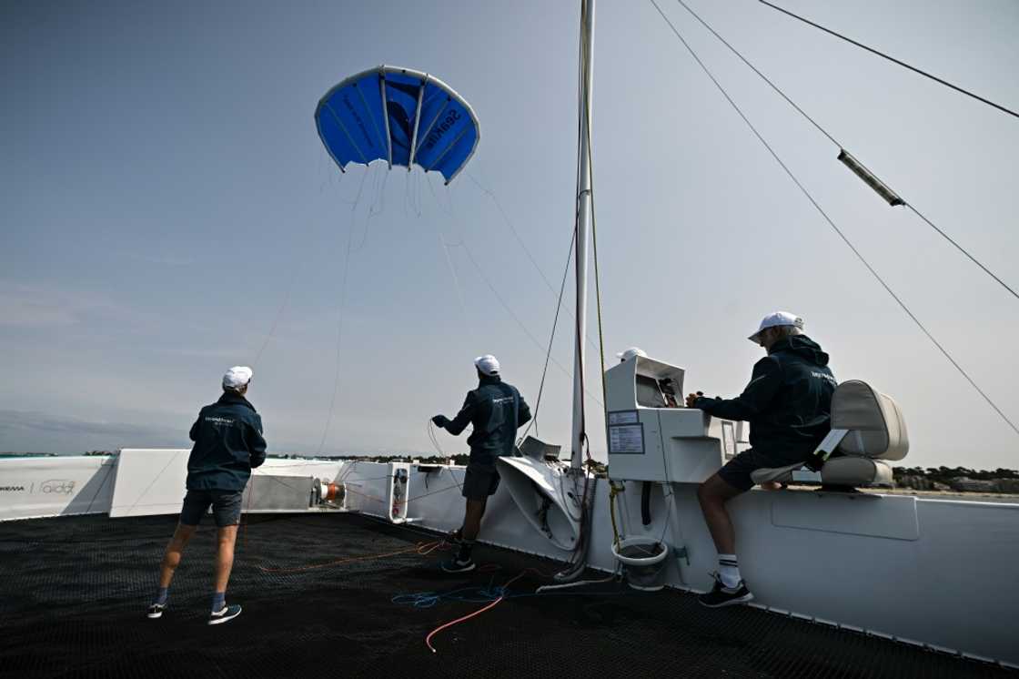 The startup Beyond The Sea tests a blue inflatable kite sail the size of a small studio to pull a specially-designed catamaran across the water