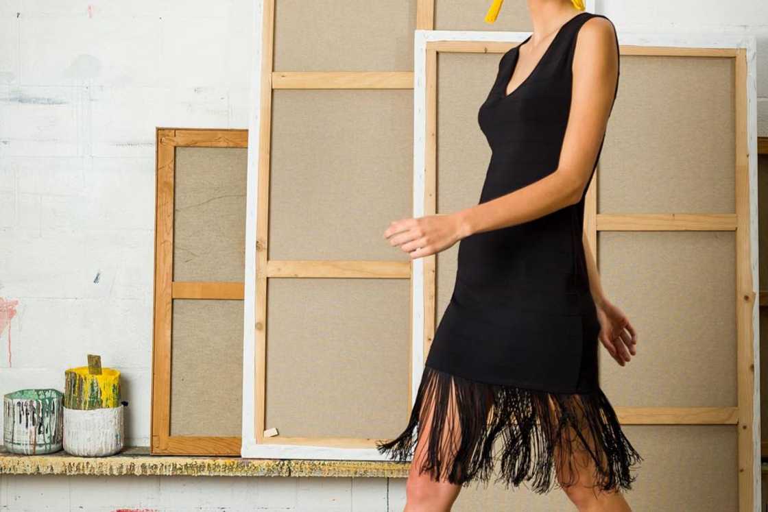 A woman is wearing a black dress with fringe A woman is wearing a black dress with fringe