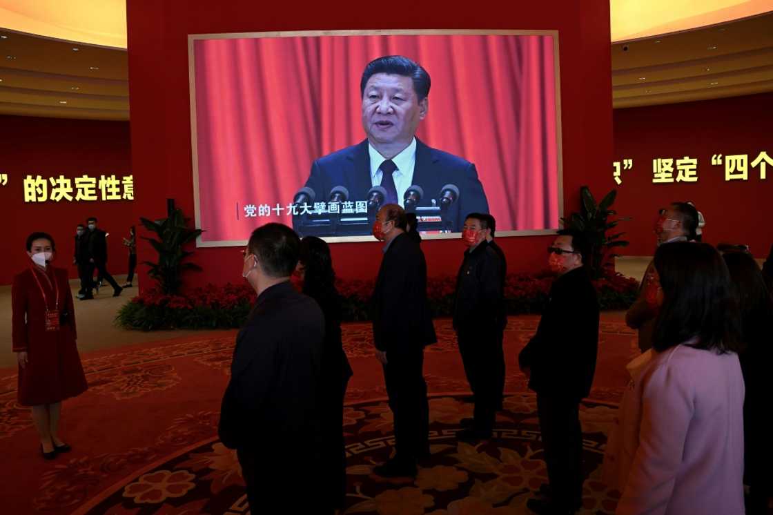 Visitors stand in front of a screen showing Chinese President Xi Jinping during an exhibition at the Beijing Exhibition Center on national achievements Visitors stand in front of a screen showing Chinese President Xi Jinping during an exhibition at the Beijing Exhibition Center on national achievements