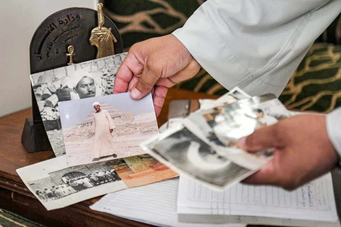 Excavator Mostafa Abdo Sadek shows pictures of family members who helped uncover the treasures of the tombs of Saqqara, southwest of Cairo